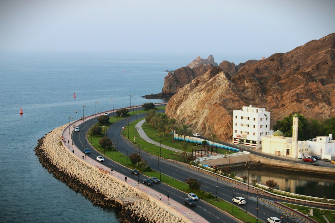طريق في مسقط مع سيارة ومنظر حضري في عُمان